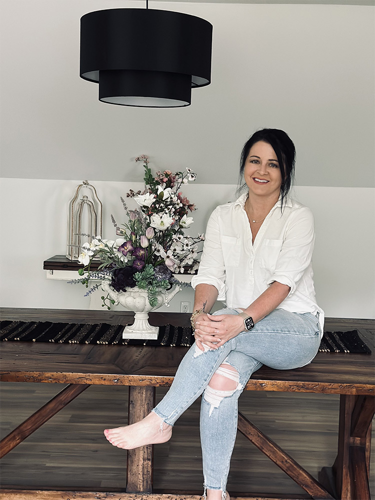 photo of Sabrina in jeans sitting on a wood bench