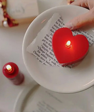 photo of a heart shaped candle with lit flame
